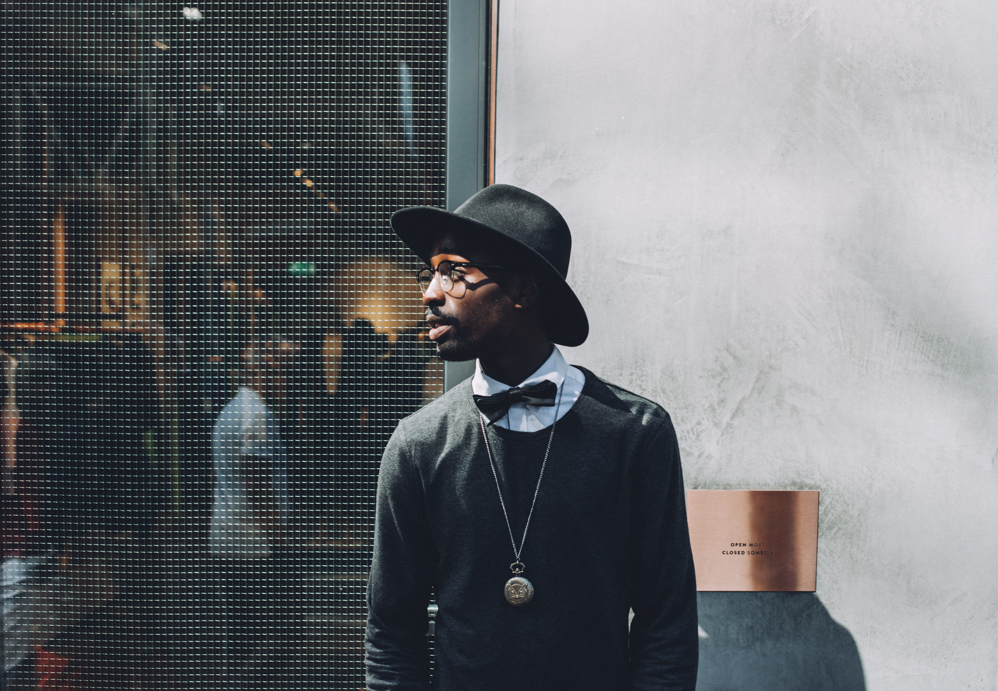 Man Wearing Black Hat a Bow and a Sweat Shirt on a Backstage