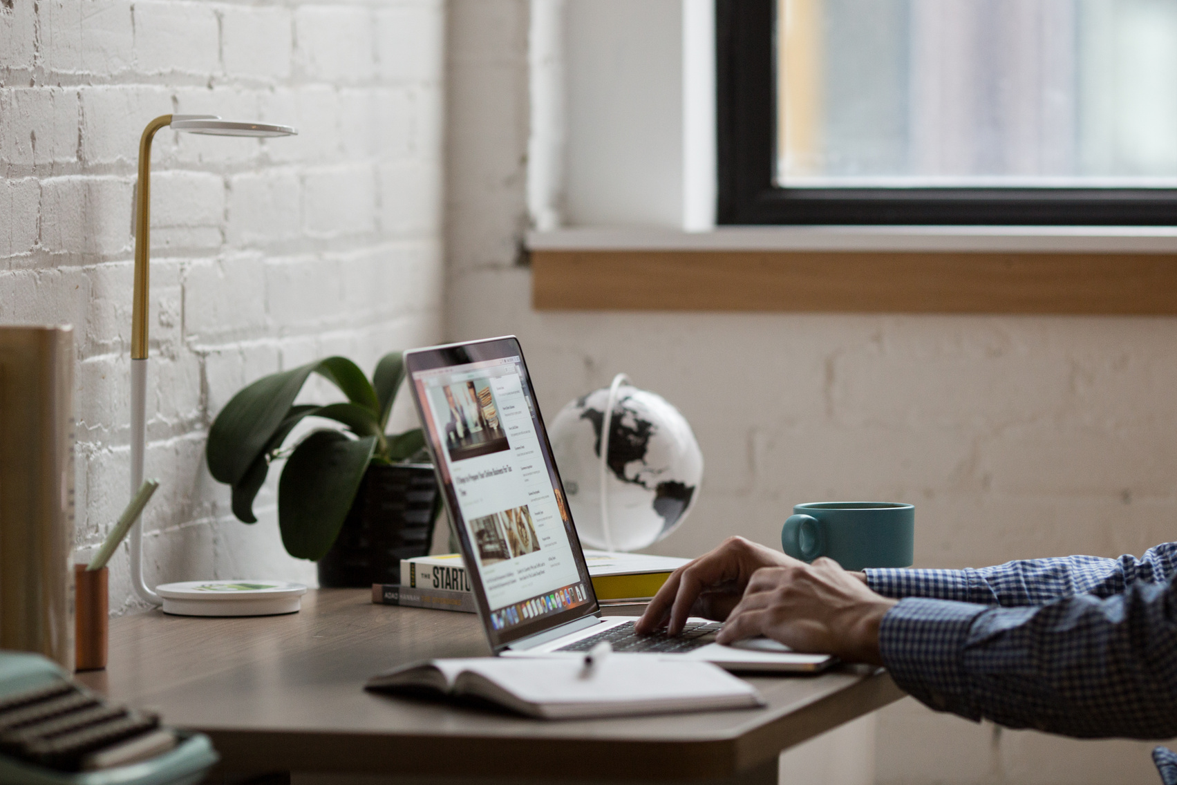 Man Sitting in Front of Turned-on Laptop on Brown Wooden Desk