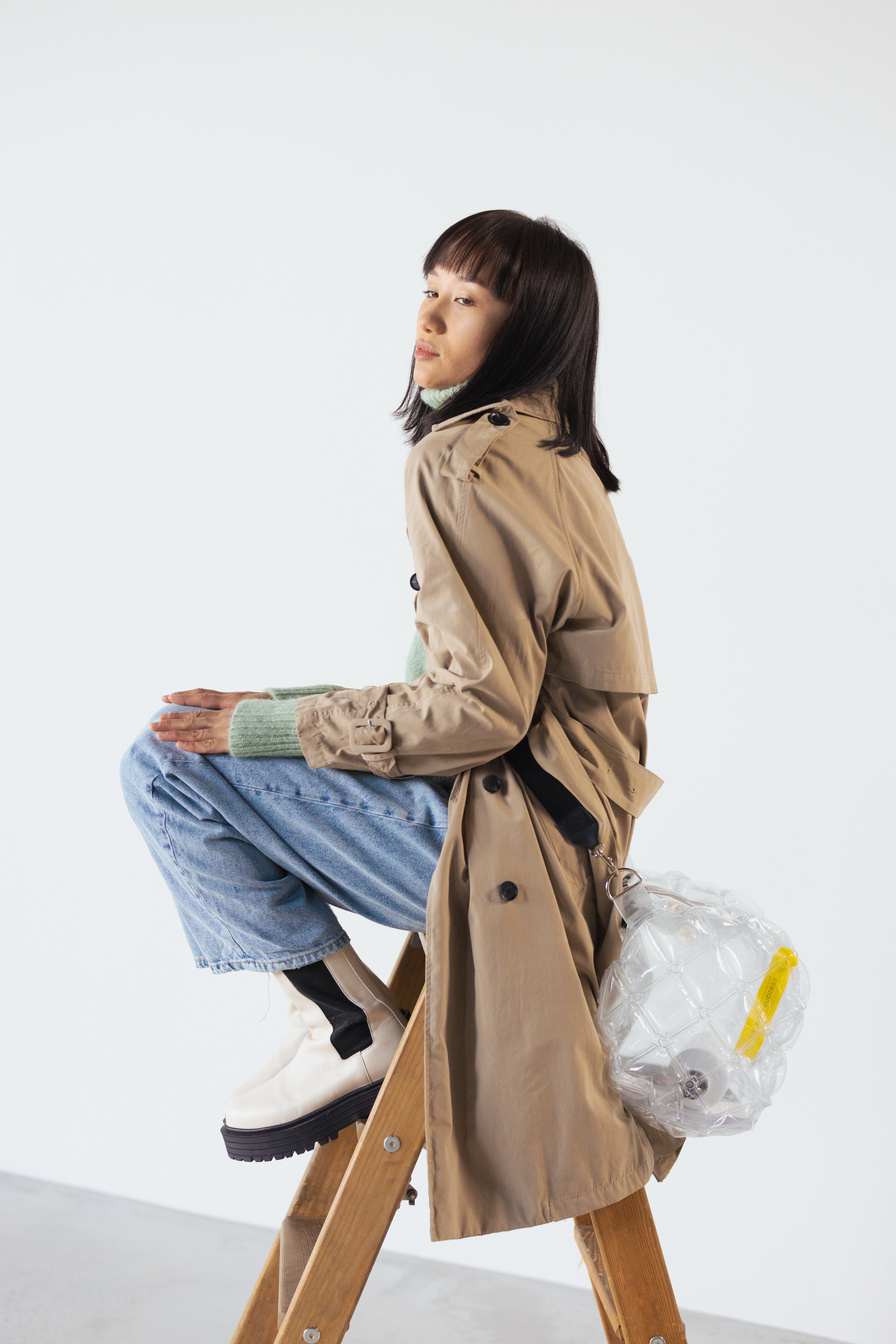 A Woman Posing while Sitting on Wooden Ladder