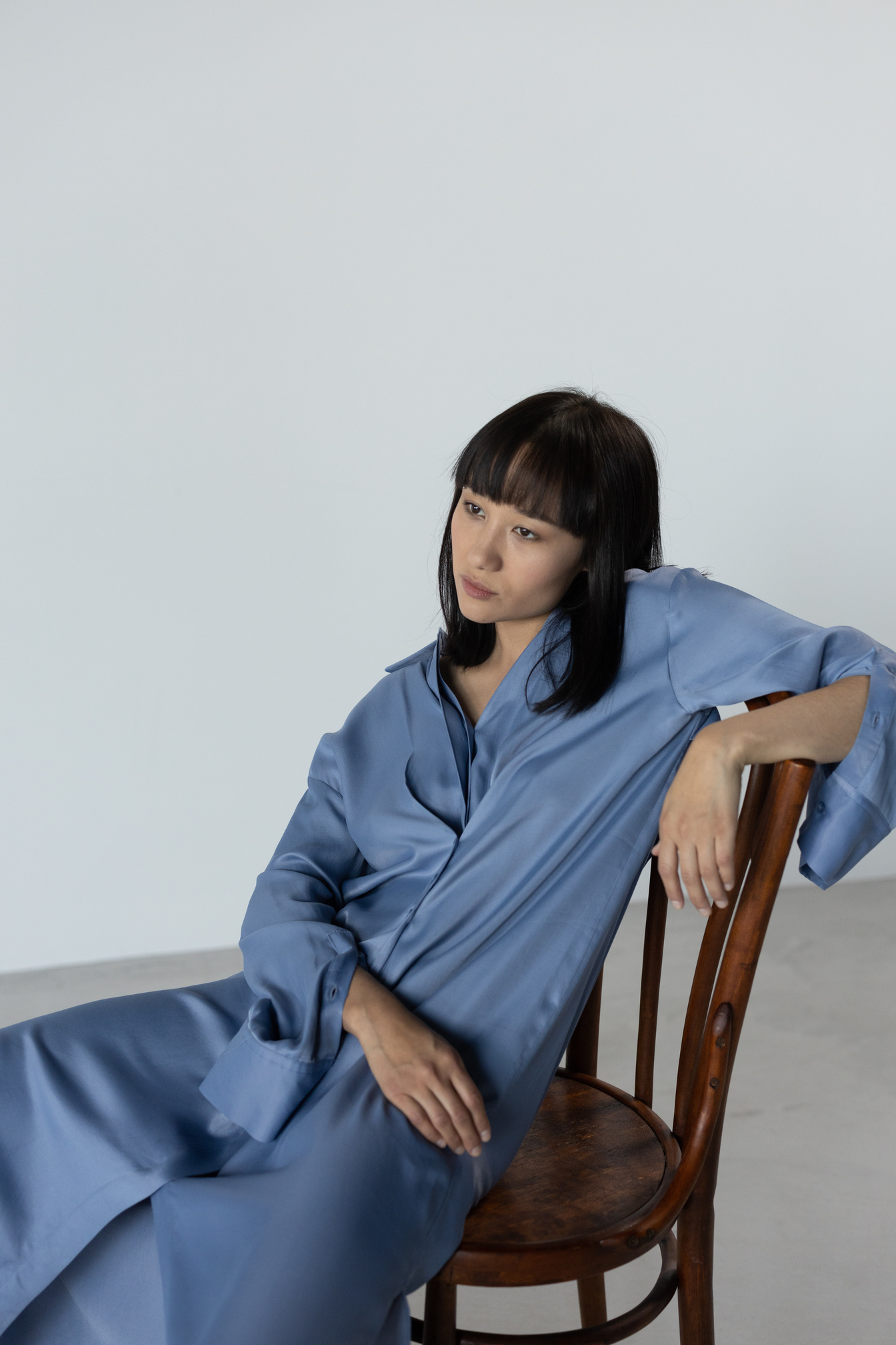 Woman in Blue Silk Dress Sitting on a Chair