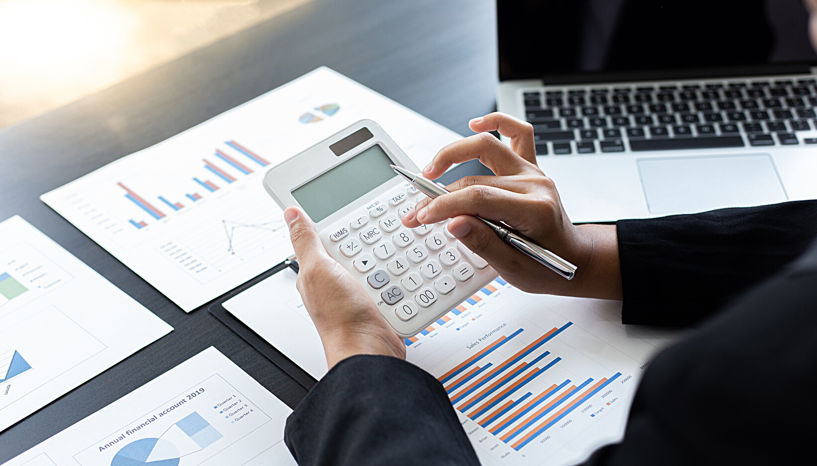 Businesswoman Using a Calculator and Pen